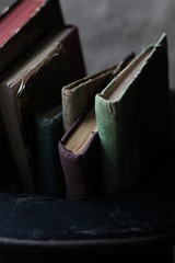 Old books and a cylinder on wooden background