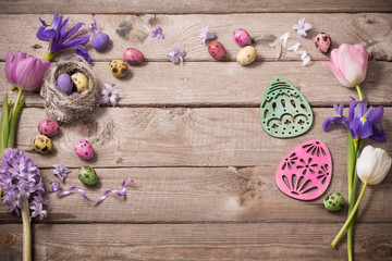 Easter eggs with spring flowers on wooden background