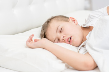 Young boy is sleeping with his mouth open, snoring