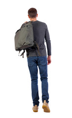 Naklejka premium back view of walking man with green bag.