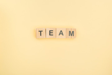 top view of team lettering made of wooden cubes on yellow background