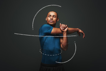 Keeping those muscles flexible. Sportsman is stretching standing over dark background. Graphic...