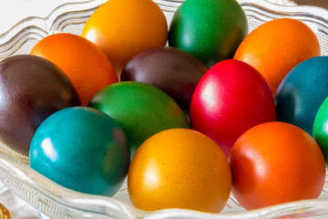 Many Easter colored eggs in the basket.  Colorful, red, green ,blue, yellow and orange eggs