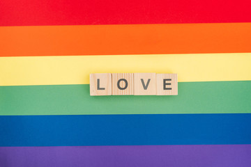 top view of love lettering made of wooden blocks on paper rainbow background