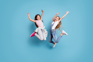 Full length body size view of two people nice-looking crazy lovely attractive cheerful carefree straight-haired pre-teen girls having fun great weekend time overjoy isolated over blue pastel
