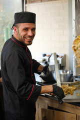 Man at the kitchen cook kebab