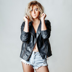 Beautiful and sexy blonde posing on a gray background. Studio photo.