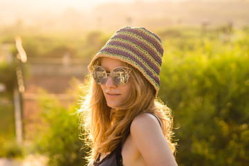Young Beautiful Woman Summer Sunset  Green Nature Portrait Wears Hipster Hat, Sunglasses, and Dress