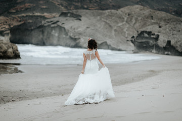 Fototapeta na wymiar The bride walks alone on the beach.