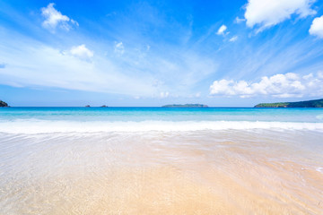 Beautiful amazing gold colored sandy beach with soft waves isolated with sunny blue sky. Concept of tropical calm tourism idea, copy space, close up