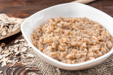 Rye porridge on dark wooden background.