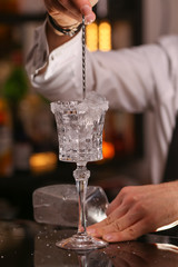 Margarita alcohol cocktail with lime ice. Alcohol cocktail on black background surface.  Barmen is making Margarita