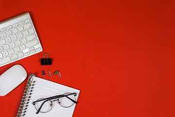 computer keyboard, notebook, and other equipment The top view lay flat on the red background