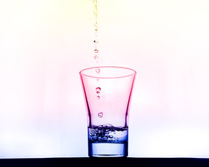 multicolored glass pouring clean water on a abstract background