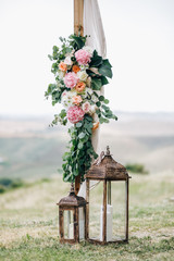 Italian wedding decoration. Green eucalyptus, oranges and pink flowers decorate wedding altar