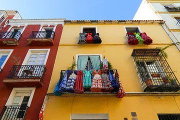 Flamenco dance dresses hanging on balcony like funny decoration of a facade 