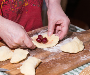 Woman making dumplings with cherries