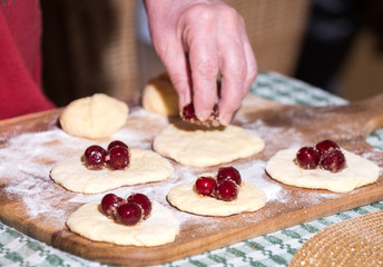 Obraz na płótnie Canvas Woman making dumplings with cherries