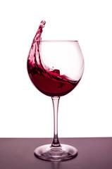 splashes of red wine in a wineglass