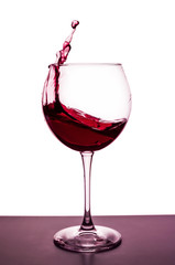 splashes of red wine in a wineglass