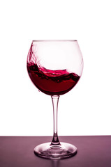 splashes of red wine in a wineglass