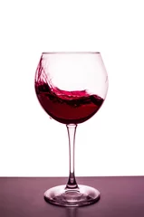 Fotobehang splashes of red wine in a wineglass © Roman