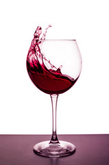 splashes of red wine in a wineglass