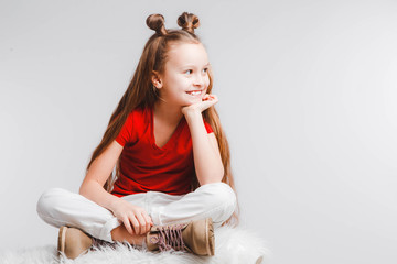Emotional happy teen girl wearing a red t-shirt and horns shaped hair.