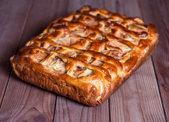Fresh baked apple pie on the natural wood background
