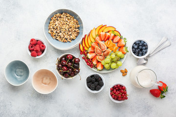 Raw vegan gluten and grain free paleo granola or muesli made from nuts. Fruit berries platter, strawberries blueberries raspberries peach figs red currant, above view, selective focus