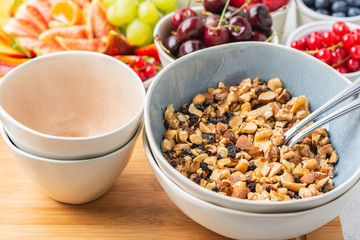 Raw vegan gluten and grain free paleo granola or muesli made from nuts. Fruit berries platter, strawberries blueberries raspberries peach figs red currant, side view, selective focus