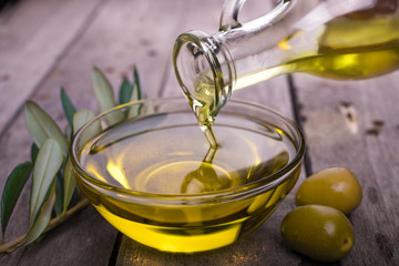 Bowl with olive oil on wooden table