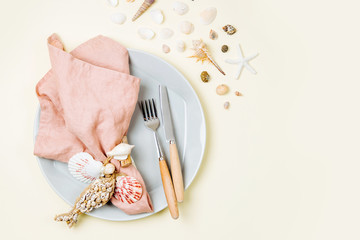 Tableware and sea decorations for serving a festive table. Plates, wine glasses and cutlery on blue...