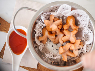 Fried sausages in aluminium bowl serves with tomato sauce on table, menu for kids.