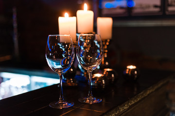 empty wine glasses and candles with illumination lights background. Romantic dinner dating night in bar or restaurant . 