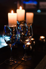 empty wine glasses and candles with illumination lights background. Romantic dinner dating night in bar or restaurant . 