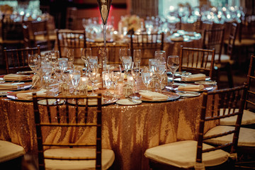 Dinner table setting. Table served in pink and gold colors full of sparkling glass