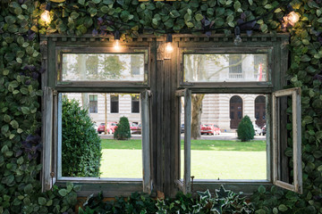 Fototapeta na wymiar wooden framed window with lights and green plants 
