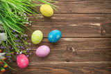 Easter eggs and spring flowers on rustic wooden background.