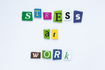 Obraz premium Abstract closeup of colored inscription text word stress at work concept on light background. Inscription text word concept, great design for any purposes. Paper art card with colored inscription text