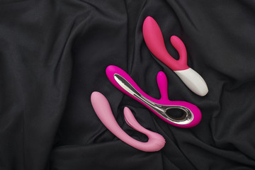 Stimulate your most sensitive area. Composition of colorful G-spot vibrators arranged on a black...