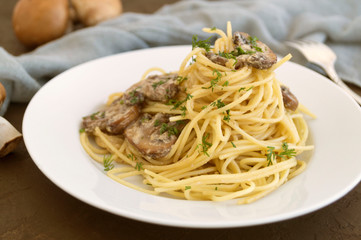 Spaghetti with mushrooms in cream sauce. on dark background