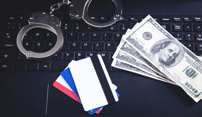 Handcuffs, money, credit cards on computer keyboard. Concept of  Cyber crime and Online fraud