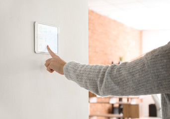 Young woman using application of smart home automation