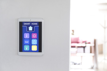Tablet computer with smart home application on wall