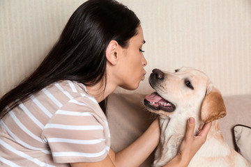 Portrait of young woman with her cute labrador dog at home