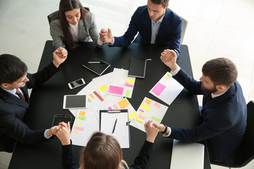 Group of people praying before meeting in office