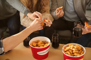 Group of friends eating nuggets at home