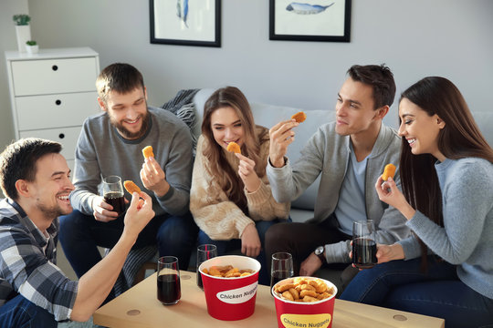 Group Of Friends Eating Nuggets At Home