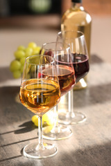 Glasses of different sorts of wine on table